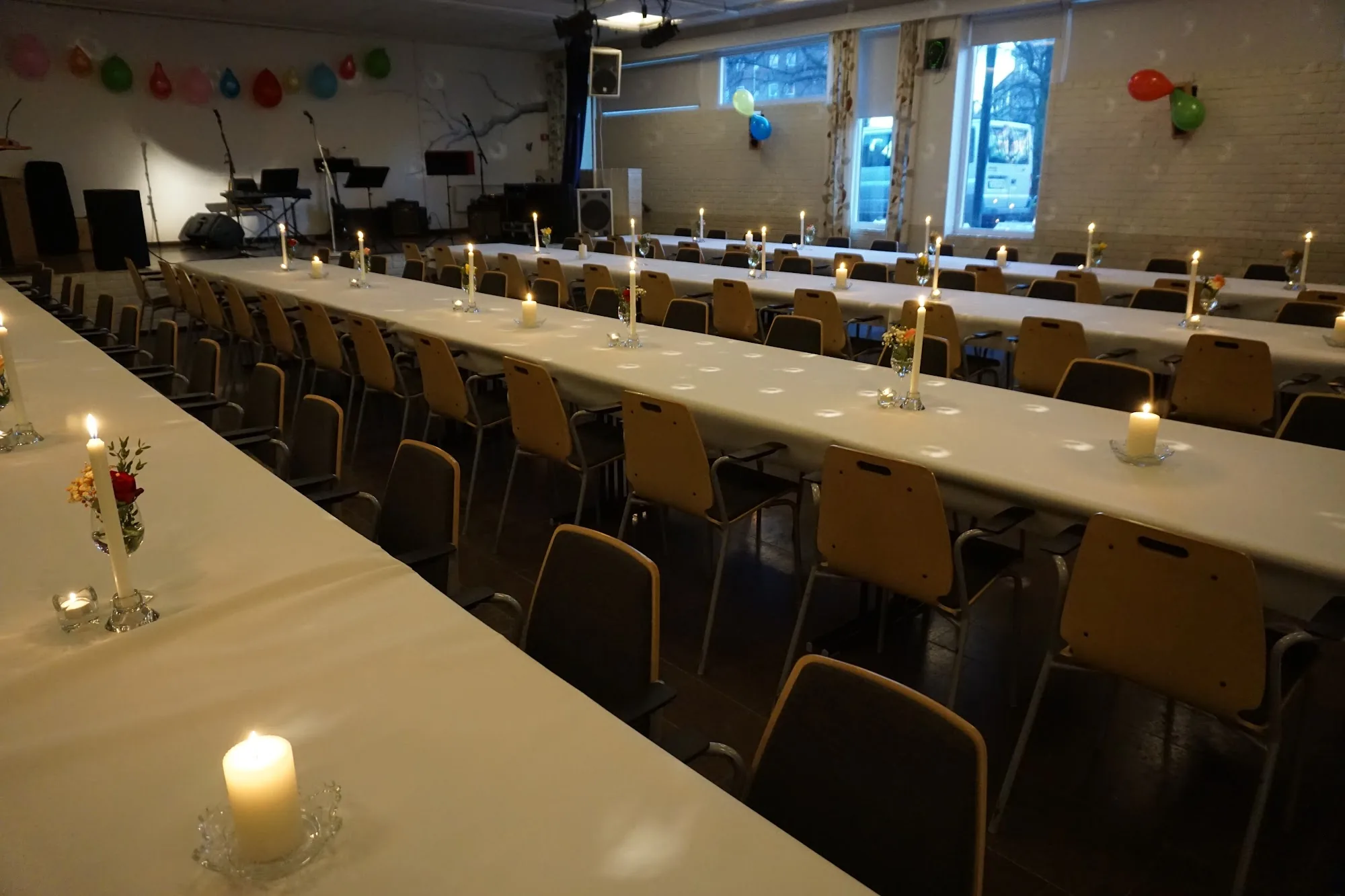 Event hall at Sagene Samfunnshus Kaysalen Oslo set for dinner with tables and music stage