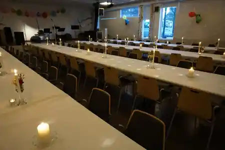 Event hall at Sagene Samfunnshus Kaysalen Oslo set for dinner with tables and music stage — salsa, bachata, kizomba venue in Oslo