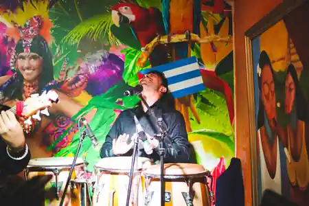 Live conga musician performing at Cuba Libre Singapore with Cuban murals — salsa, bachata venue in Singapore