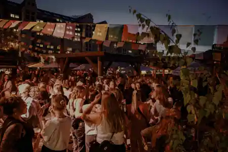Evening party crowd under festival flags at SALT Art and Music on the Oslo waterfront, salsa, bachata venue in Oslo