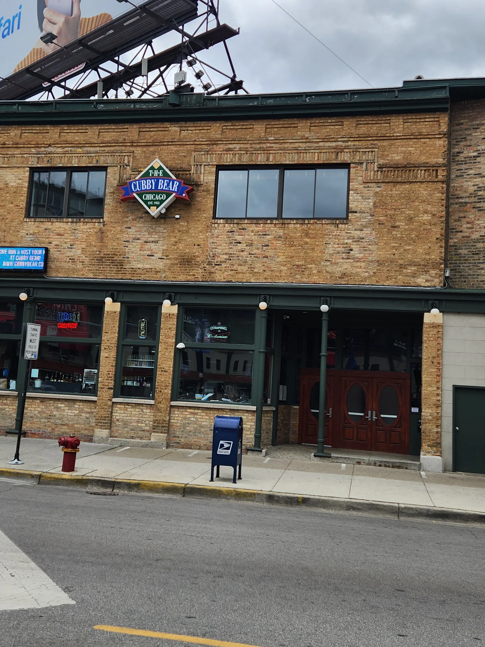 Daytime street view of The Cubby Bear brick facade with its diamond sign near Wrigley Field in Chicago