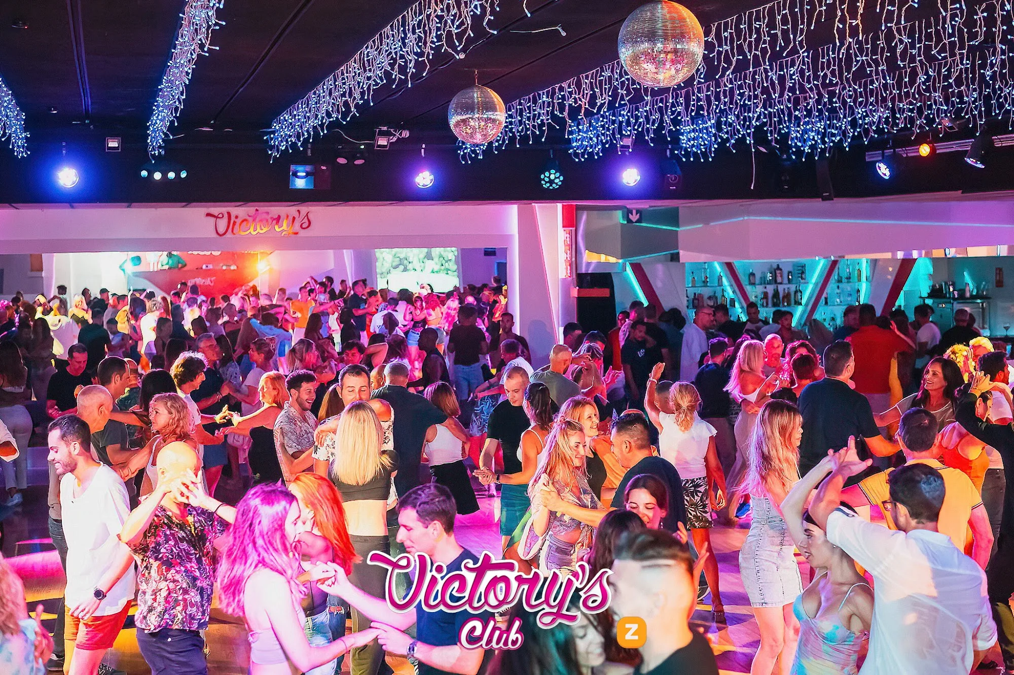 Packed dance floor with crowd and stage lights at Victory's Palma de Mallorca