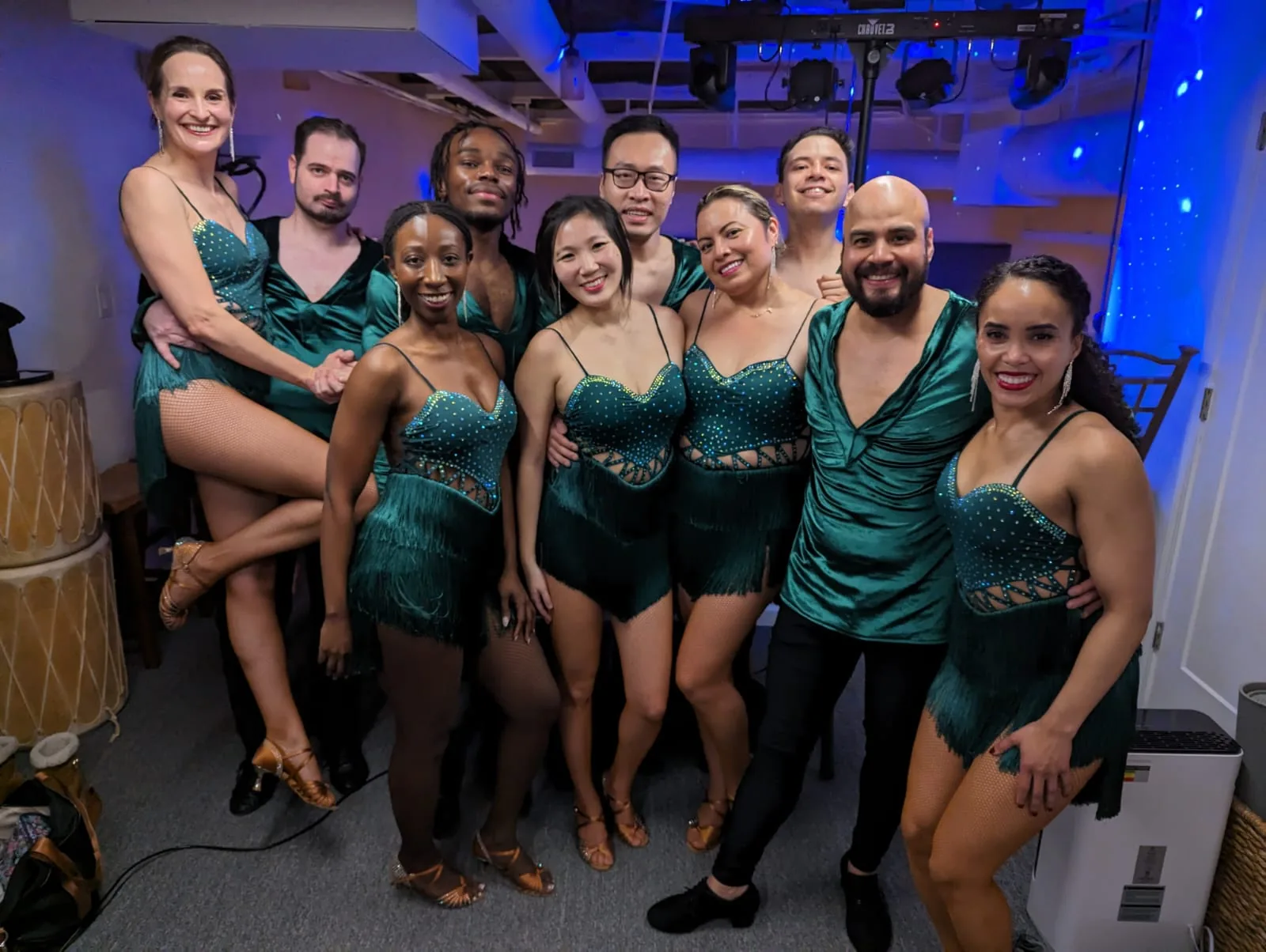 Salsa performance team in matching green costumes at a Bravo Dance School event