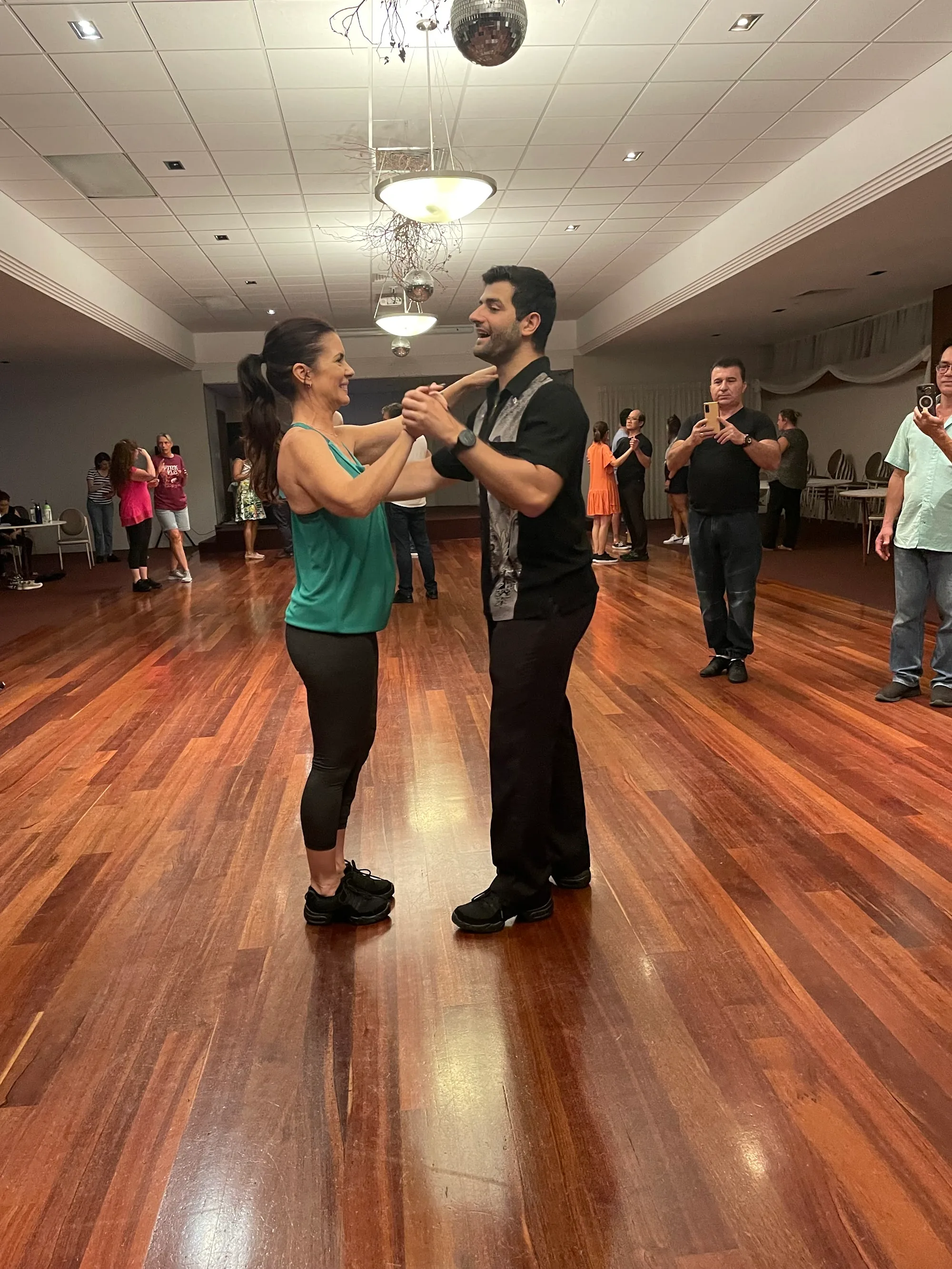 Couple dancing salsa on wooden dance floor at Danza Pasion Perth Western Australia