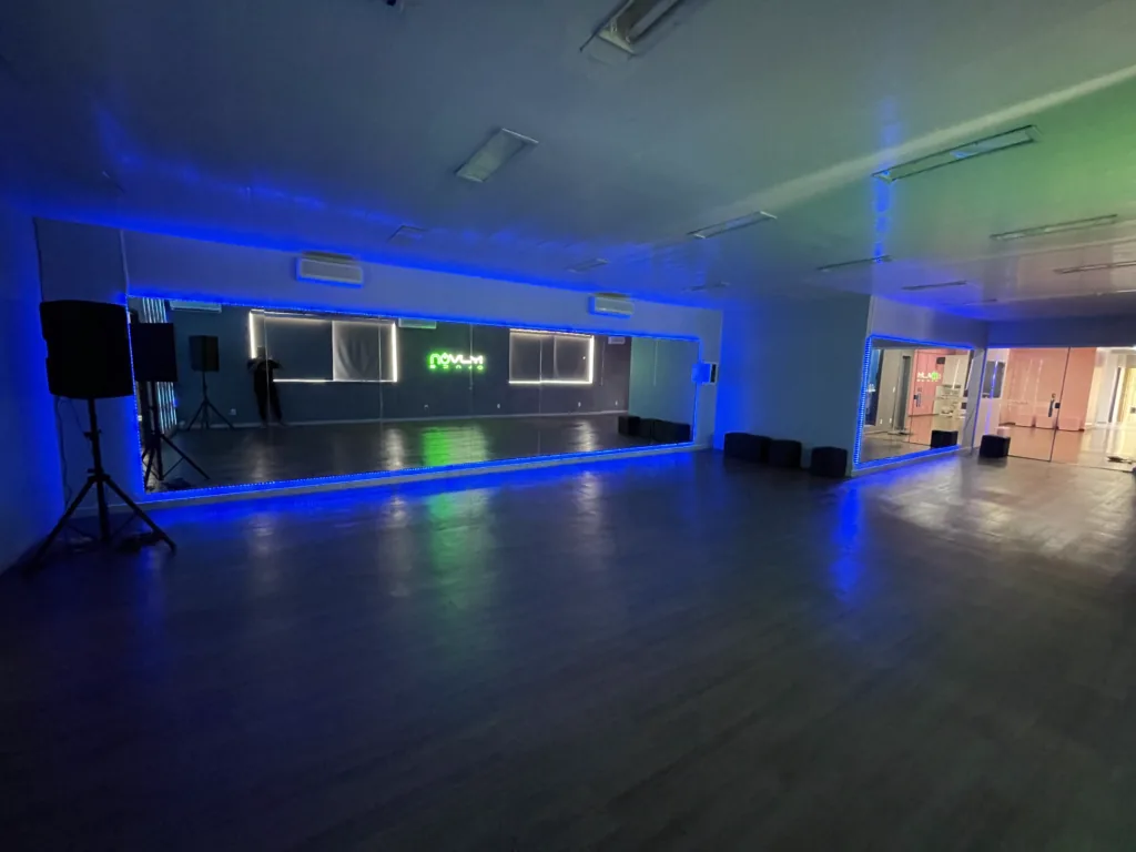 Dance floor with mirror wall and blue lighting at Muvon Dance, Brasilia