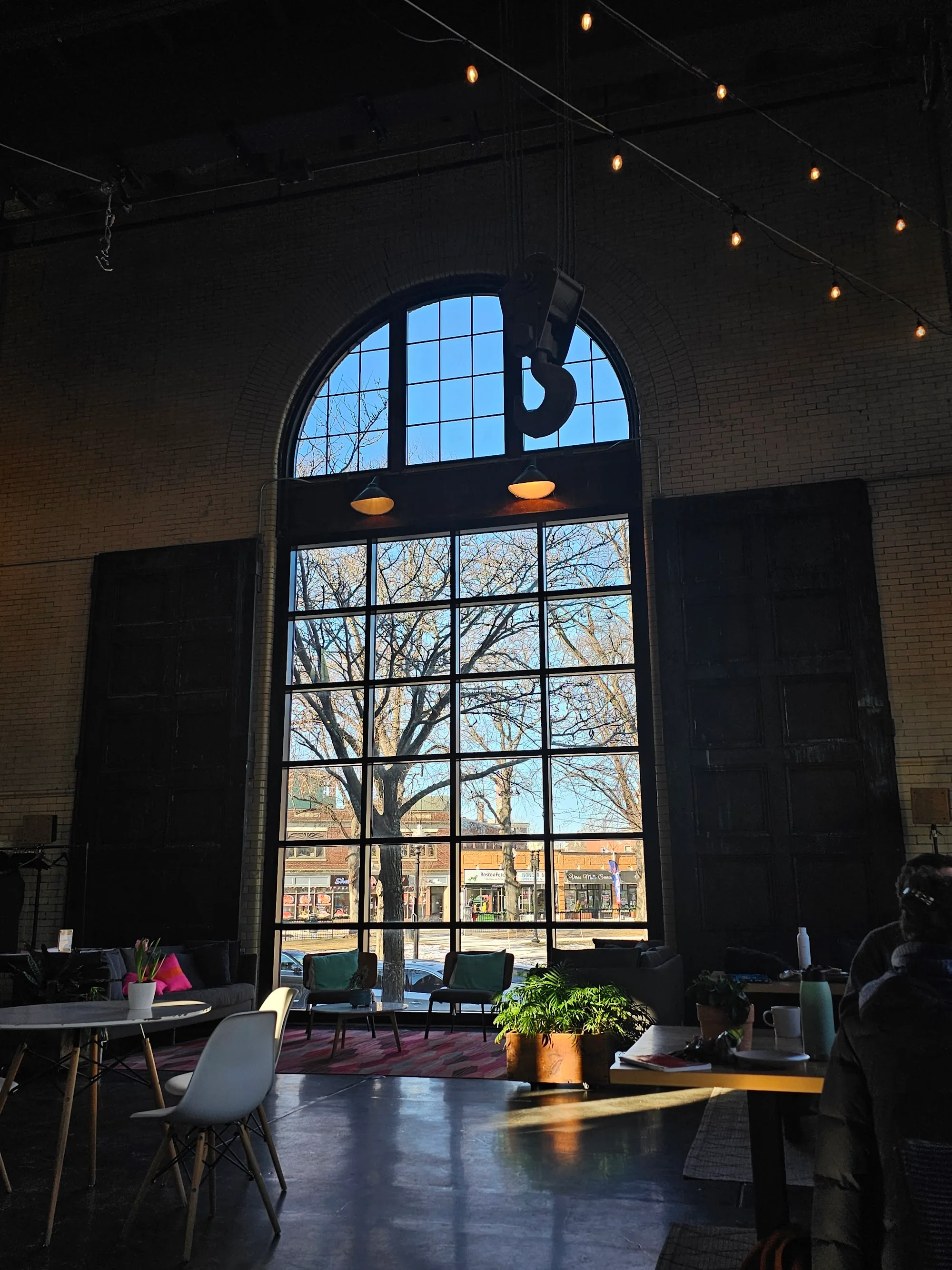 Tall arched window and lounge seating inside The Substation Boston, light-filled Latin dance venue interior