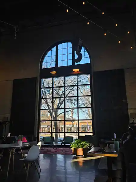 Tall arched window and lounge seating inside The Substation Boston, light-filled Latin dance venue interior — salsa venue in Boston