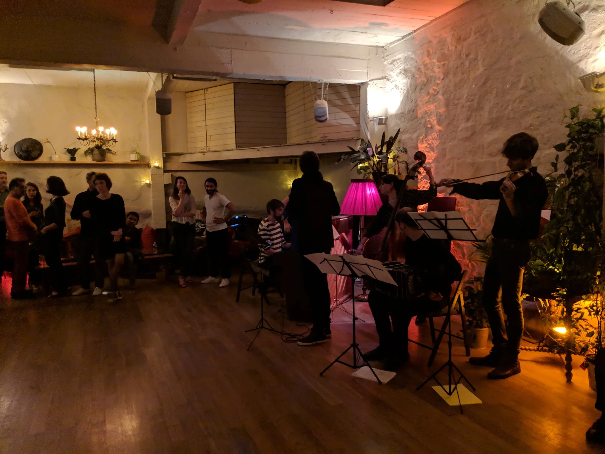 String quartet performing at Loft Lechapelais with audience watching in the candlelit space