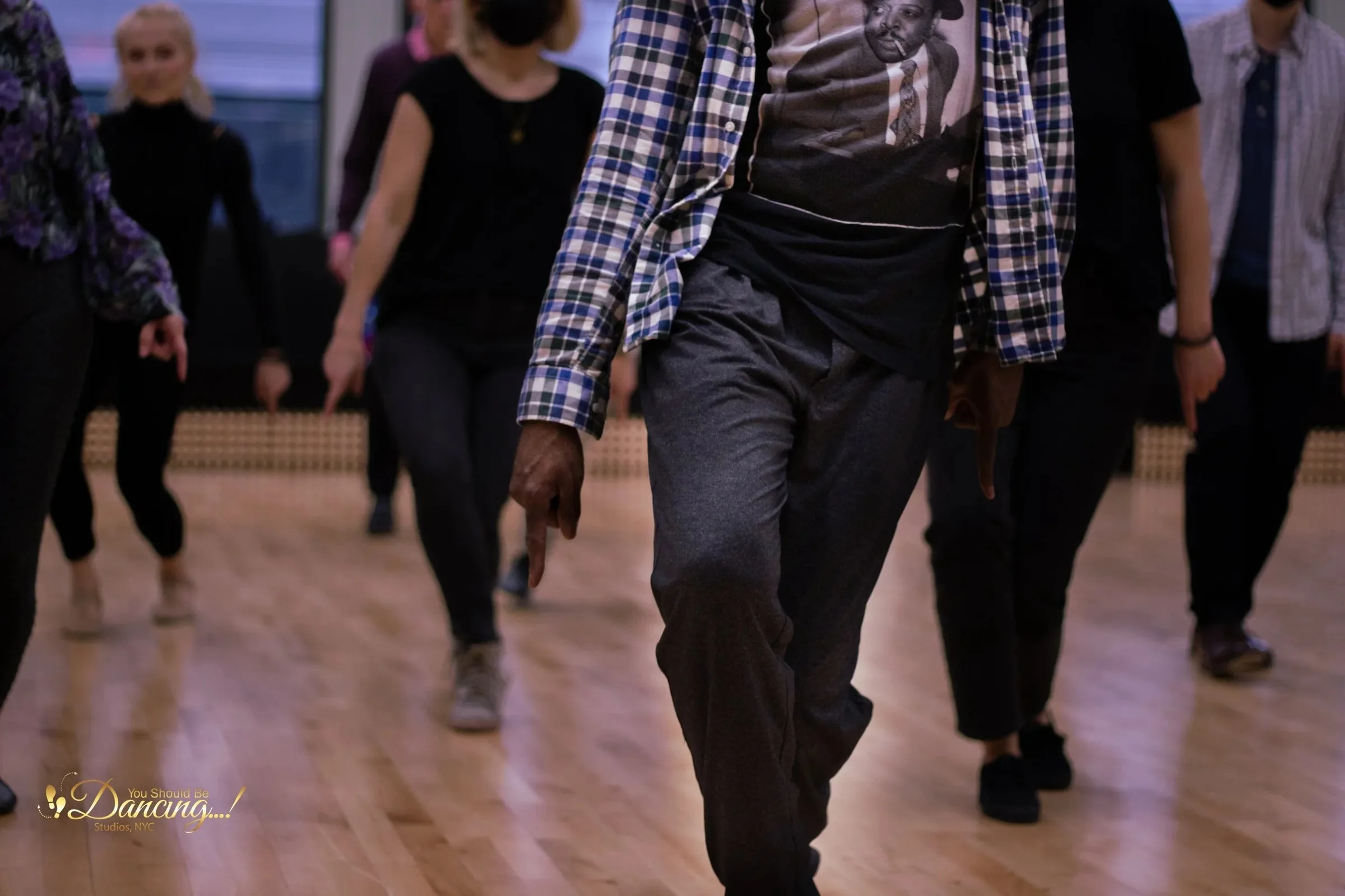 Dancers practicing footwork on the wooden sprung floor at You Should Be Dancing studio in NYC