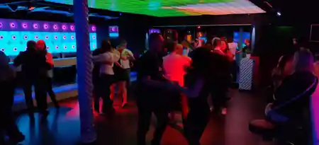 Couples dancing salsa on the dance floor at Sabor Latino Winterthur with club lights