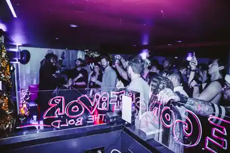Interior party crowd with DJ neon sign at Balrog Bar, Cannes — salsa, bachata venue in Cannes
