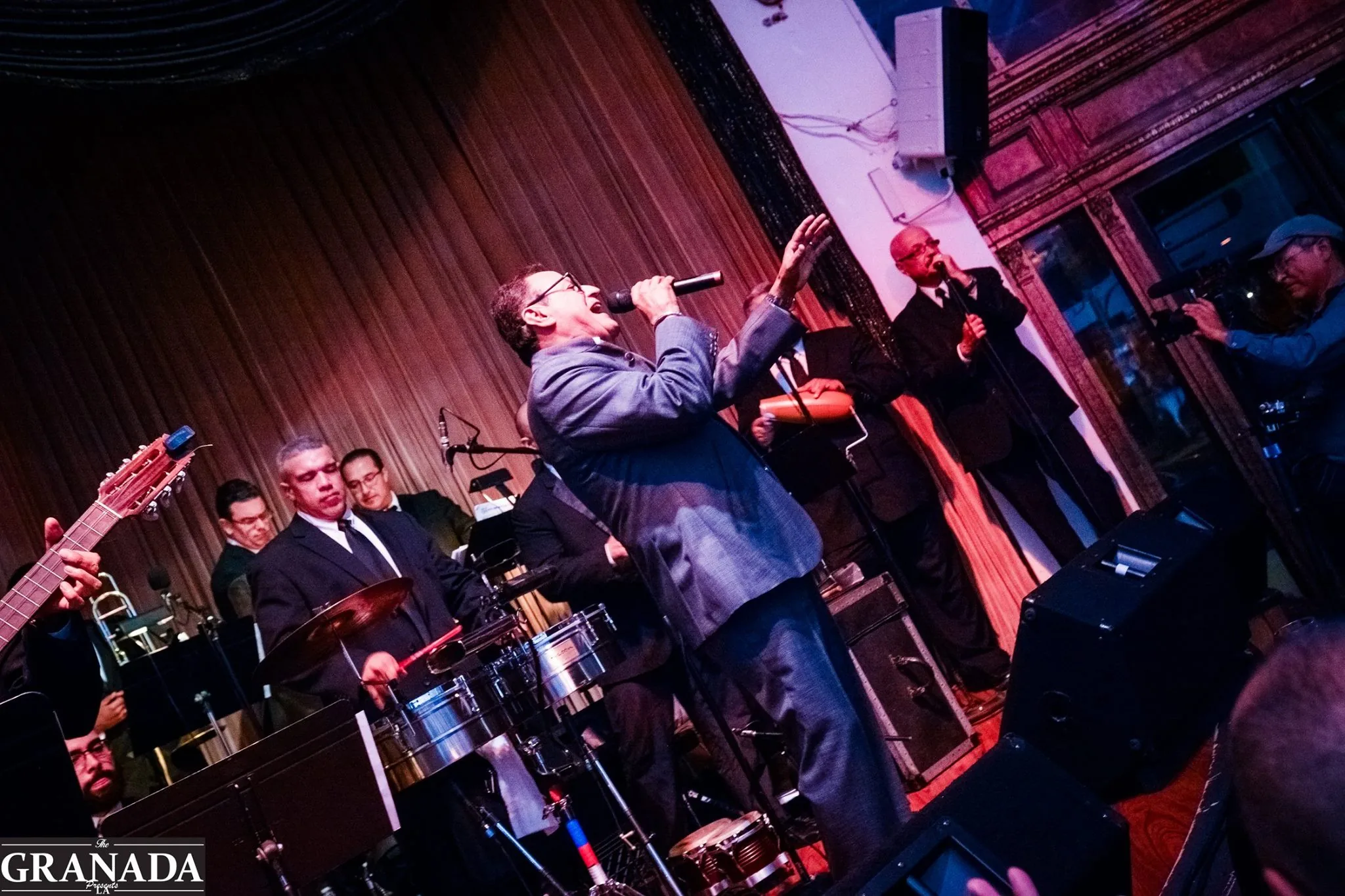 Live Latin band performing on stage with a singer and percussionists at The Granada LA, Los Angeles