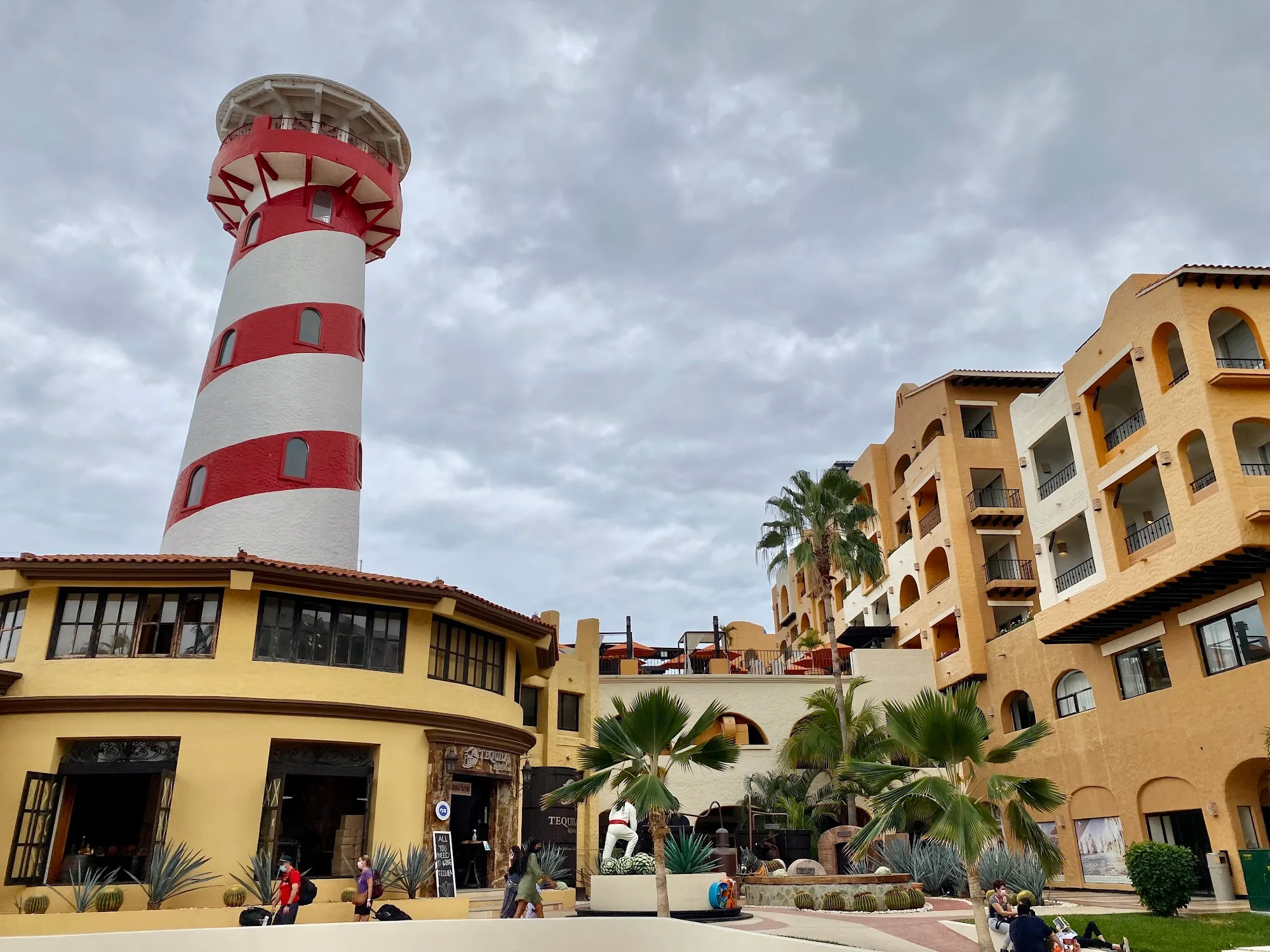 Red and white striped lighthouse tower at Tesoro Los Cabos resort with the venue buildings