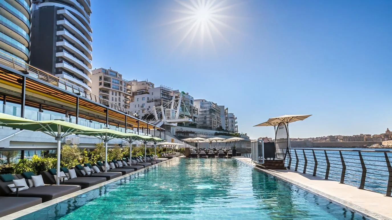 Infinity pool with Mediterranean sea view and sun loungers at Barceló Fortina Malta, Sliema