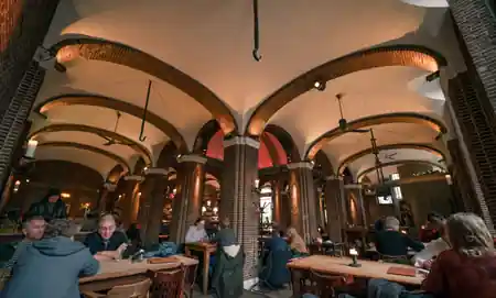 Historic hall interior of Stadscafe de Boterwaag with guests — salsa venue in Den Haag