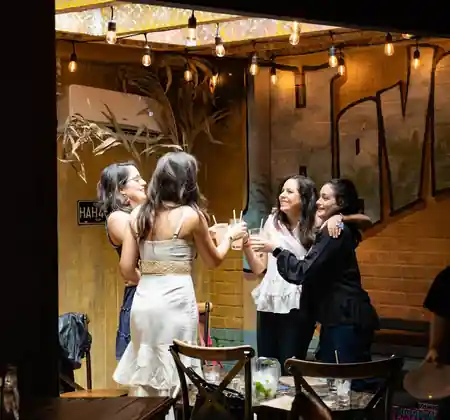 Friends toasting drinks under string lights inside Casta’s Rum Bar in Washington DC — salsa venue in Washington, D.C.