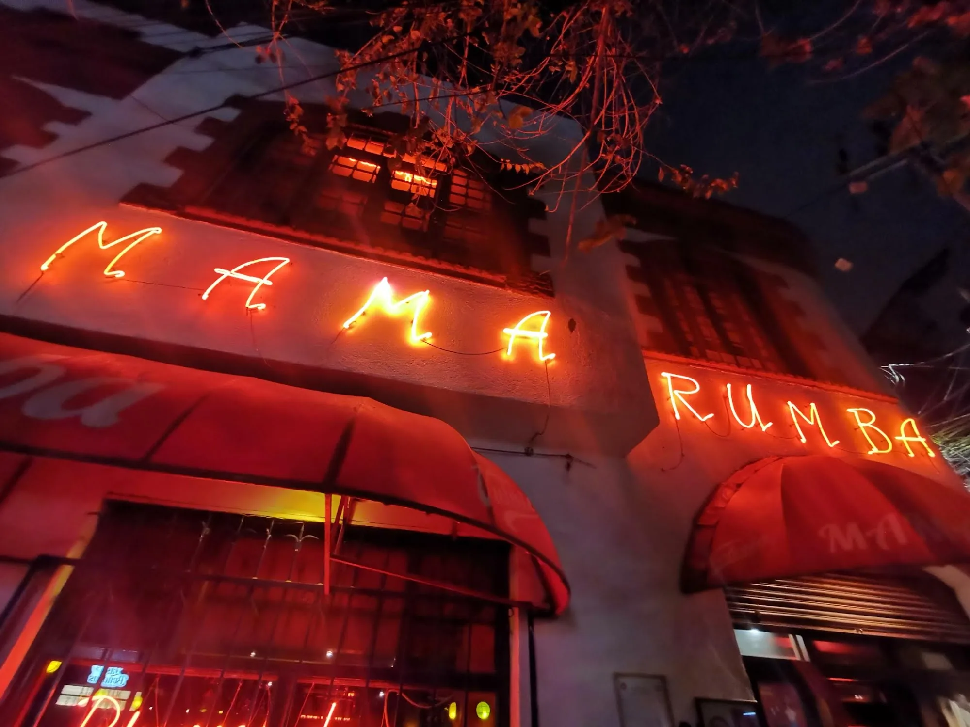 Mama Rumba neon sign glowing at the venue entrance in Madrid Spain at night