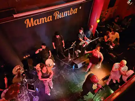 Bird's eye view of live band performing at Mama Rumba with crowd and venue sign in Madrid — bachata, salsa venue in Mexico City