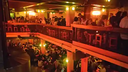 Packed two-level dance venue crowd at Mama Rumba in Madrid during a live event — bachata, salsa venue in Mexico City