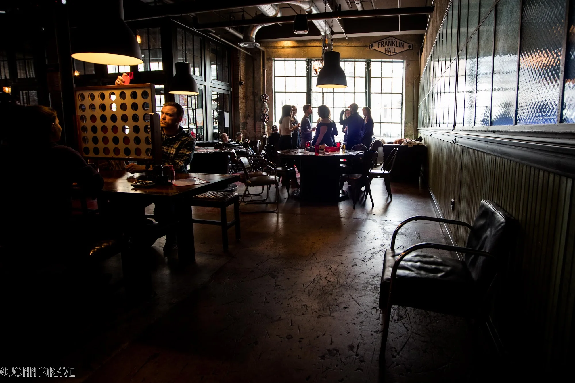 Industrial interior of Franklin Hall in Washington, D.C. with patrons and visible Franklin Hall sign