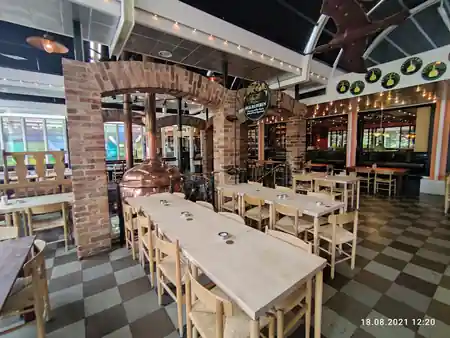 Interior of The Old Irish Pub Copenhagen with brick archways, a copper brewing kettle and string lights over wooden tables, salsa, bachata venue in Copenhagen