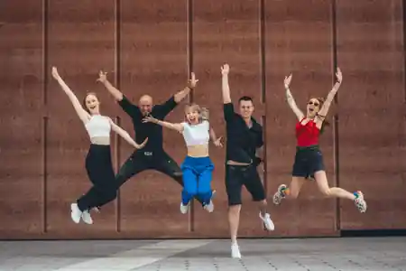 Salsa Libre dance team jumping in front of the Warsaw school building
