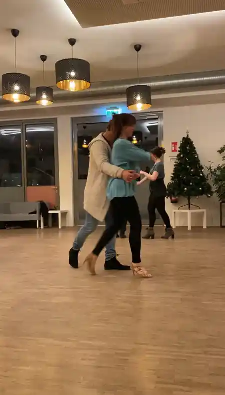 Couple dancing salsa in the studio at Salsa Akademie Heidelberg with wooden floor