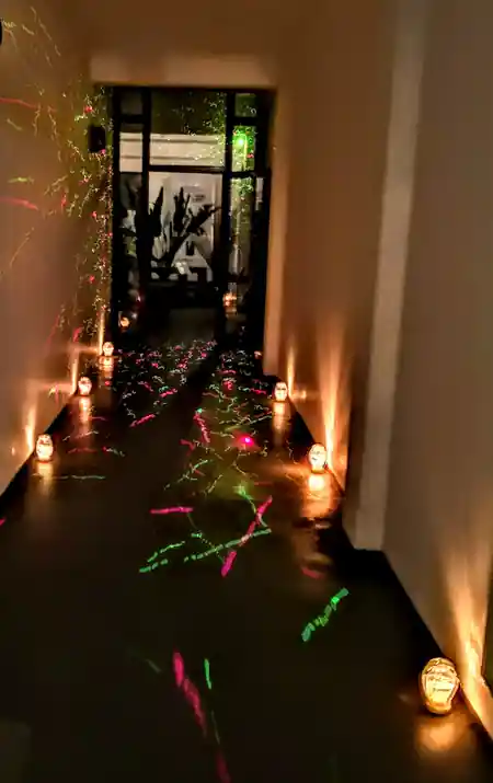 Dark venue entrance corridor with candles and laser projections at Baladin Tanzschule, Hamburg — salsa, bachata venue in Hamburg