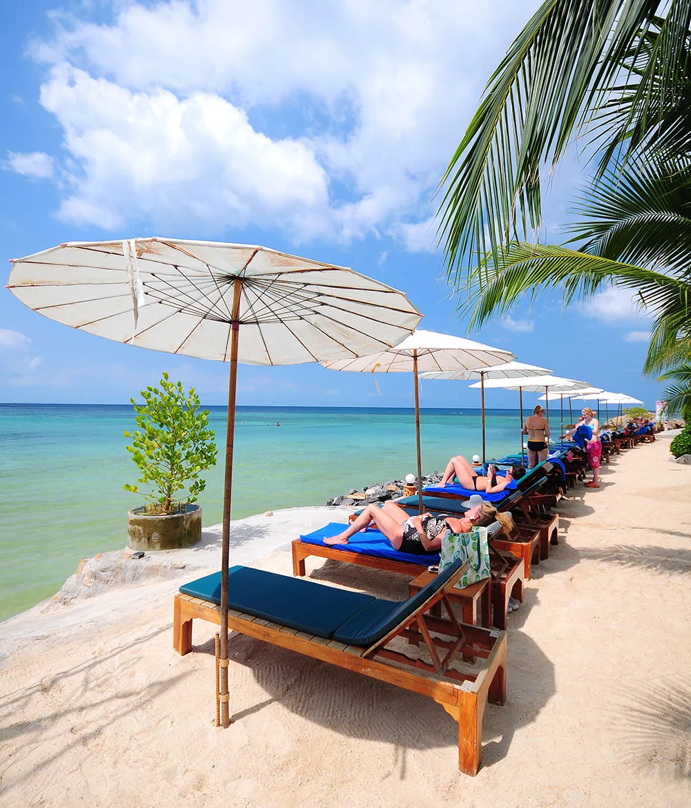 Beach loungers and parasols on the resort beach at Haad Yao Bayview Resort, Koh Phangan, Thailand