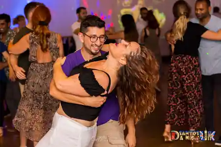 Bachata dancers enjoying a lively social dance night at St John's Angell Town Primary School in London, with couples filling the dance floor