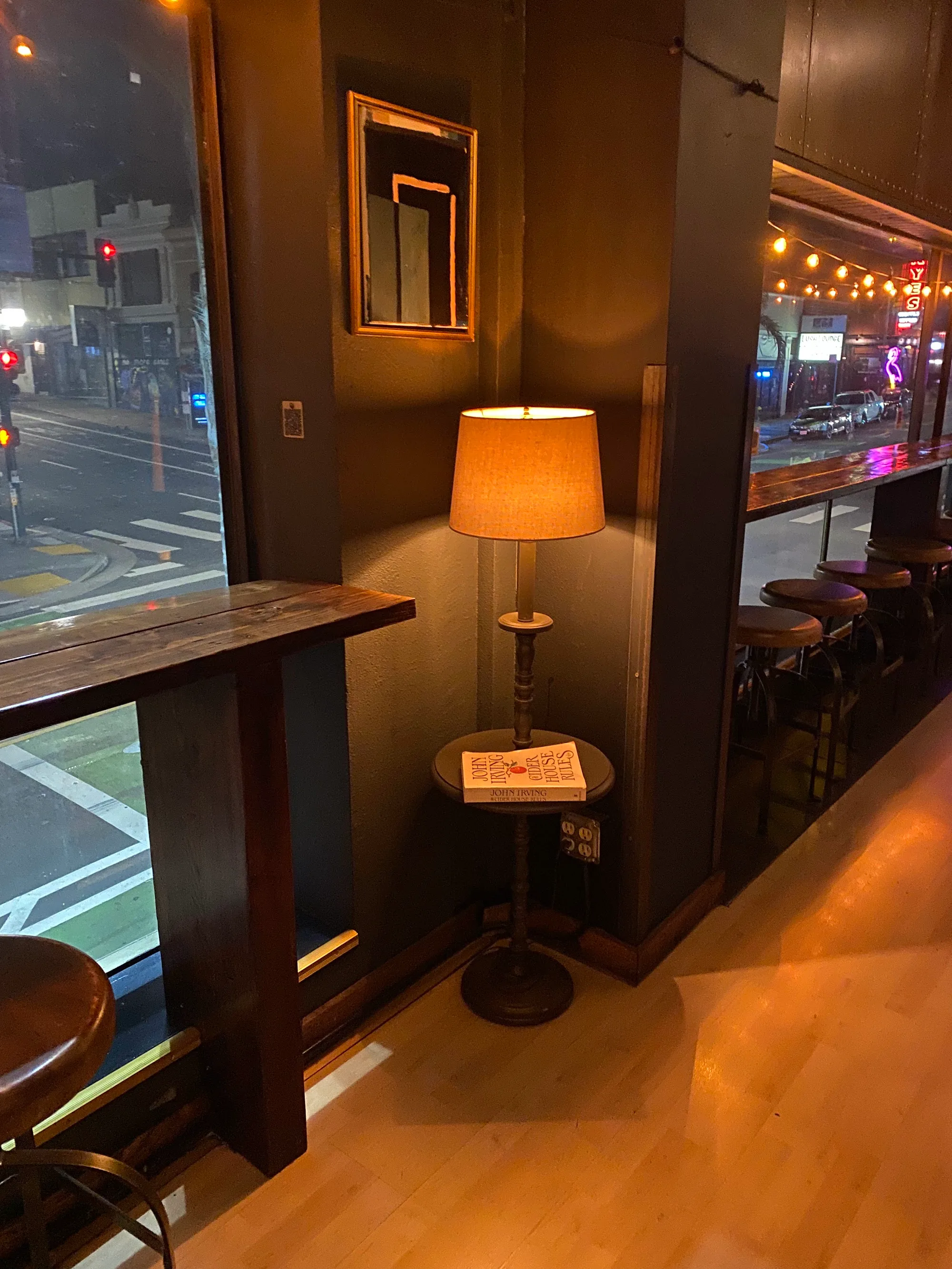 Cozy window-side seating with bar stools and warm lamp at Upcider San Francisco