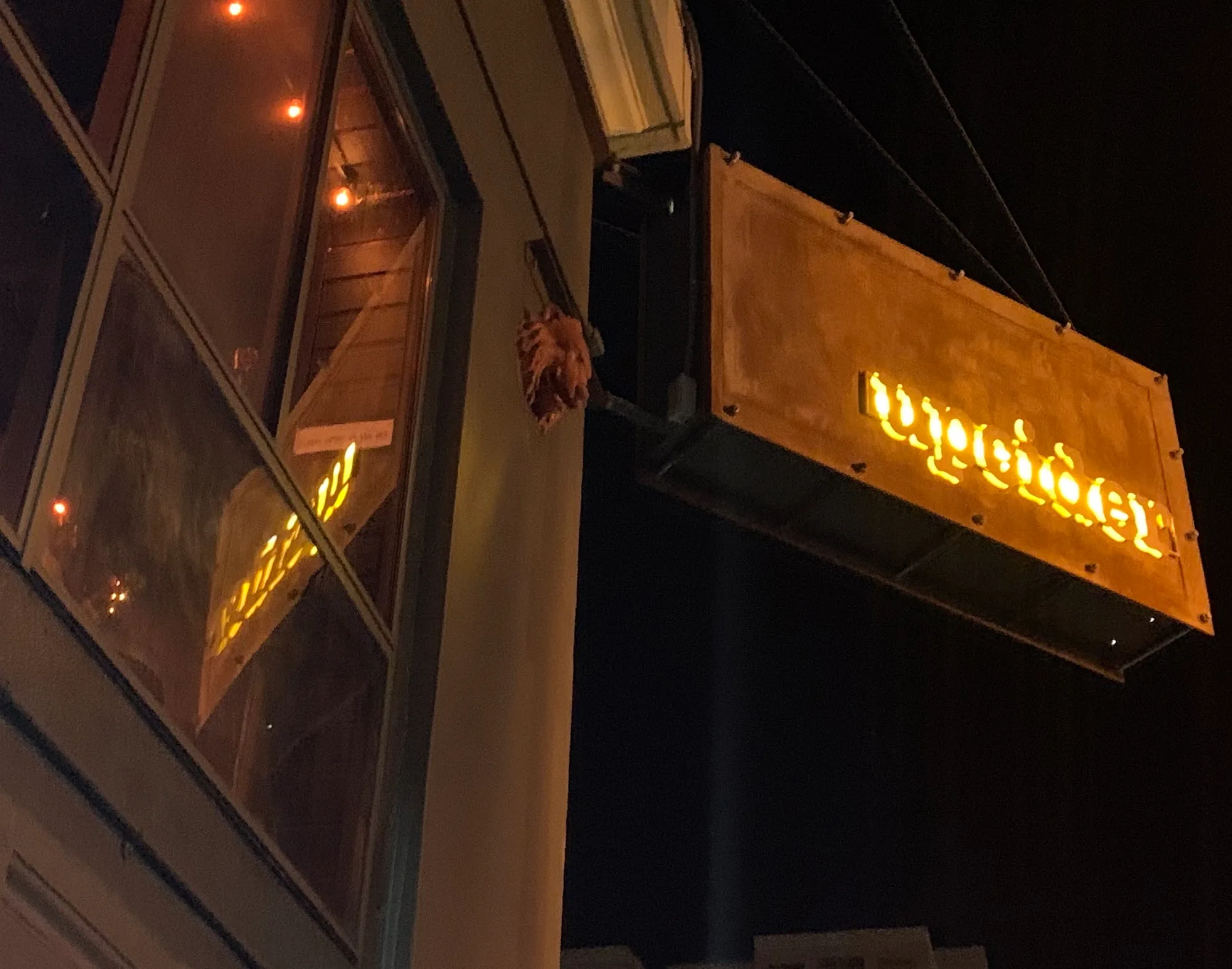Illuminated Upcider exterior signage at night on Polk Street in San Francisco