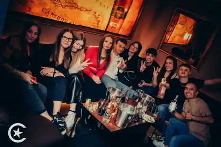 Group of friends at Cuba Libre Latin Dance Club in Poznan with Caribbean-themed decor and vintage maps — salsa, bachata venue in Poznan