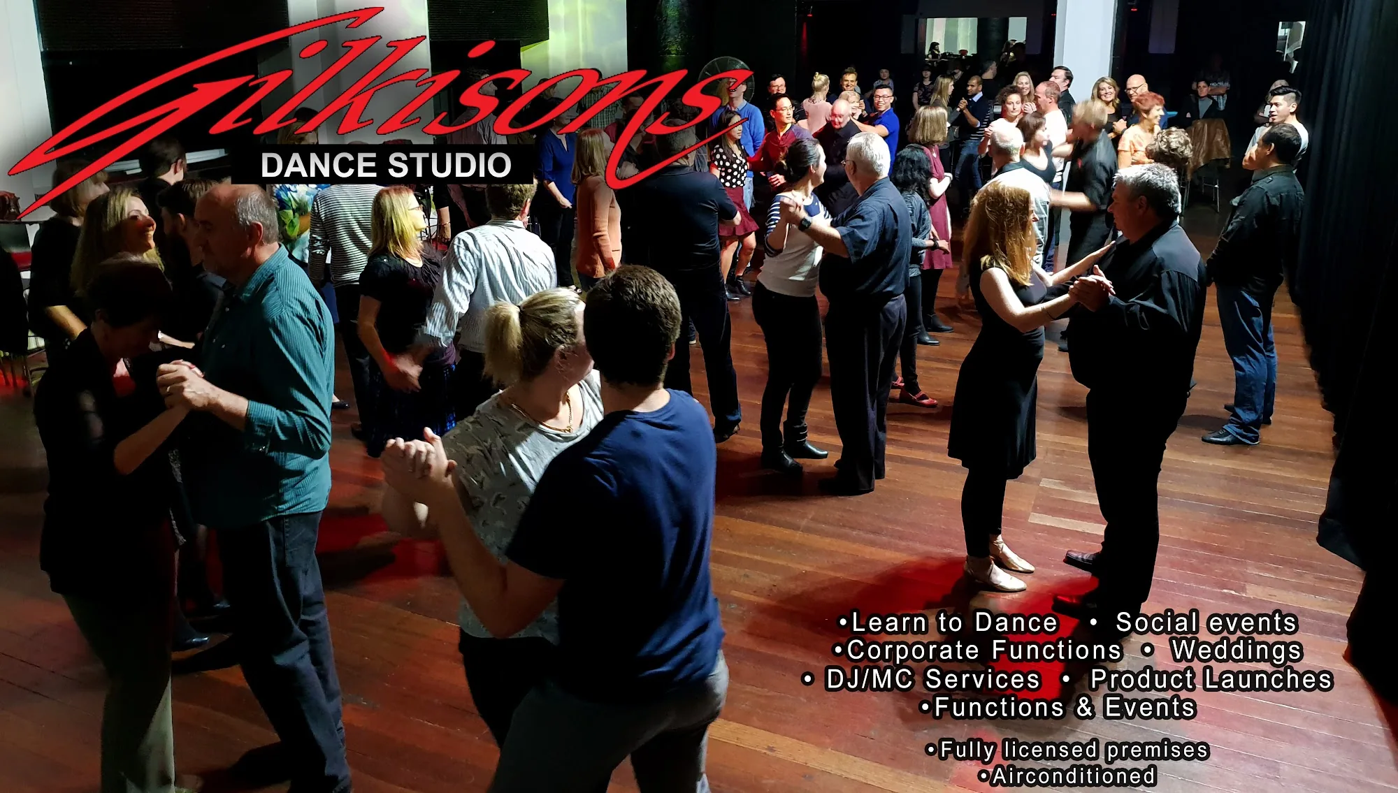 Social dance event crowd at Gilkisons Dance Studio Perth with branded signage