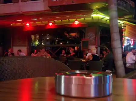 Outdoor bar terrace with crowd and red lighting at Zapata Juan-les-Pins at night — salsa, bachata venue in Juan-les-Pins