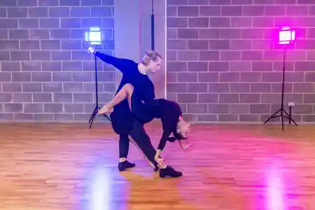 Couple performing a salsa dip on the wooden dance floor at Flow Dance Studios, London