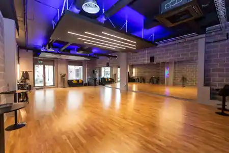 Spacious wooden dance floor with mirrored walls and blue lighting at Flow Dance Studios, Nine Elms, kizomba venue in London