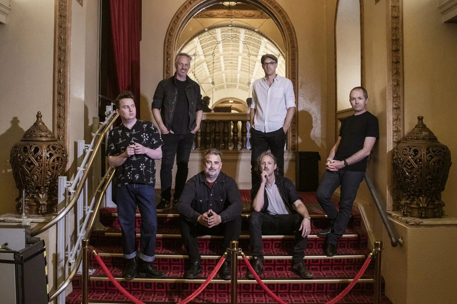 Band portrait on the ornate gold balustrade staircase inside The Night Cat, Fitzroy