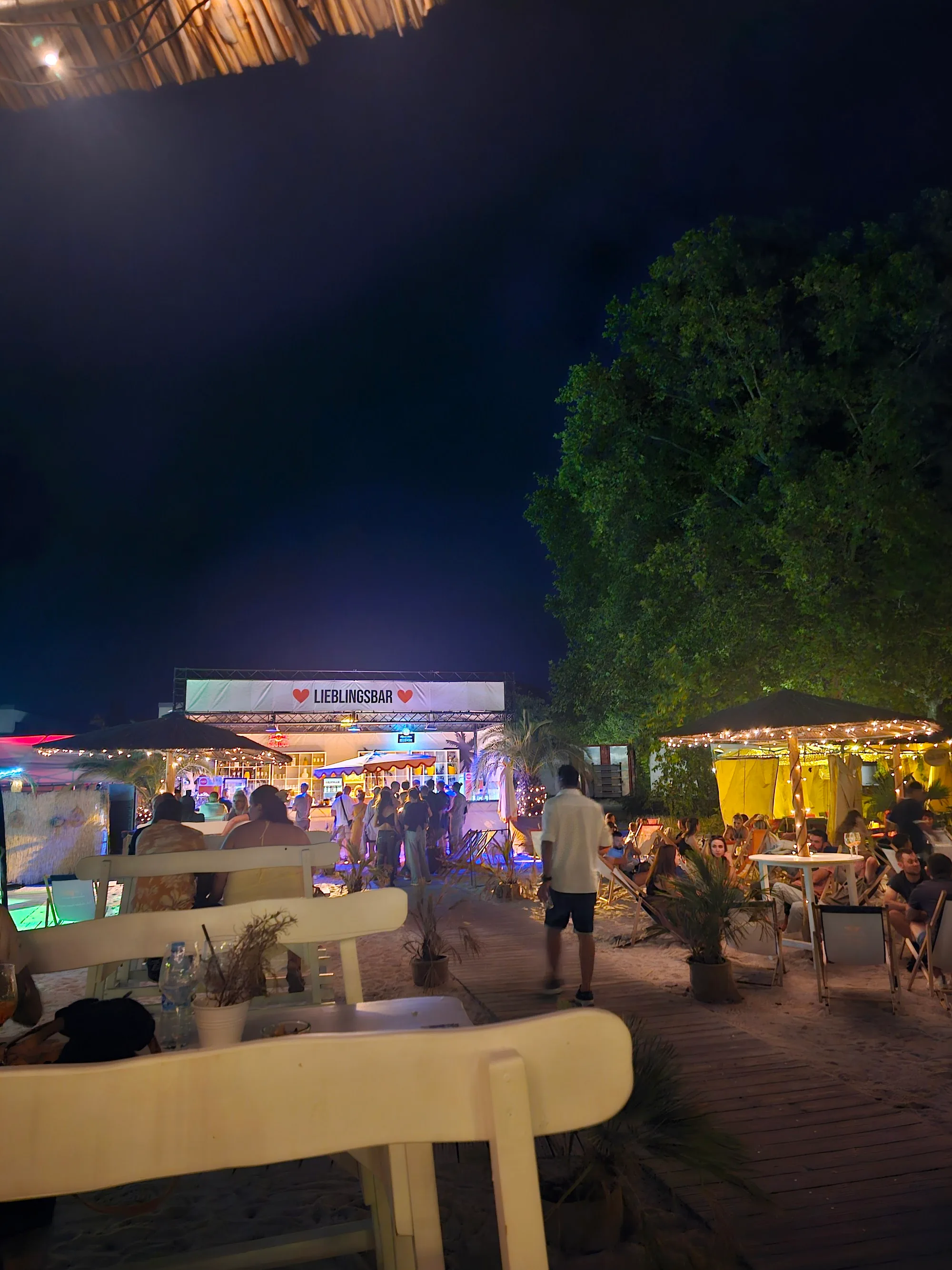 Lieblingsbar night event at Lieblingsstrand with crowd gathered under fairy lights and the venue lit up