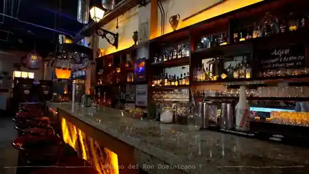 Atmospheric bar interior with warm lighting and rum bottle display at Bar Museo del Ron Dominicano — bachata, salsa venue in Santo Domingo