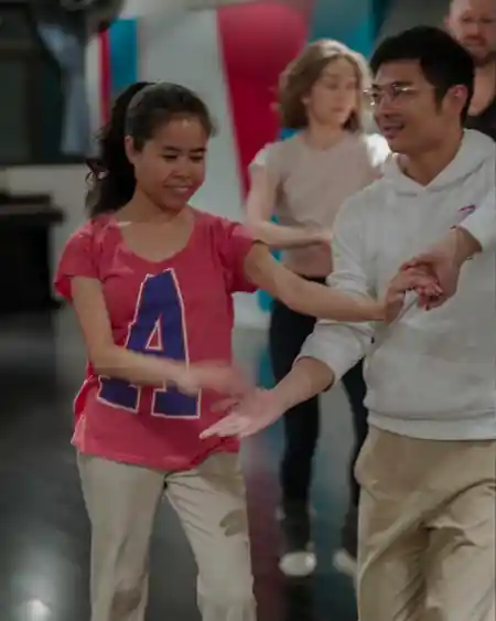 Couple practicing salsa partnering at Agozar Dance studio in Hong Kong, smiling as they work through dance moves during a class at 8th Floor Fung Woo Centre