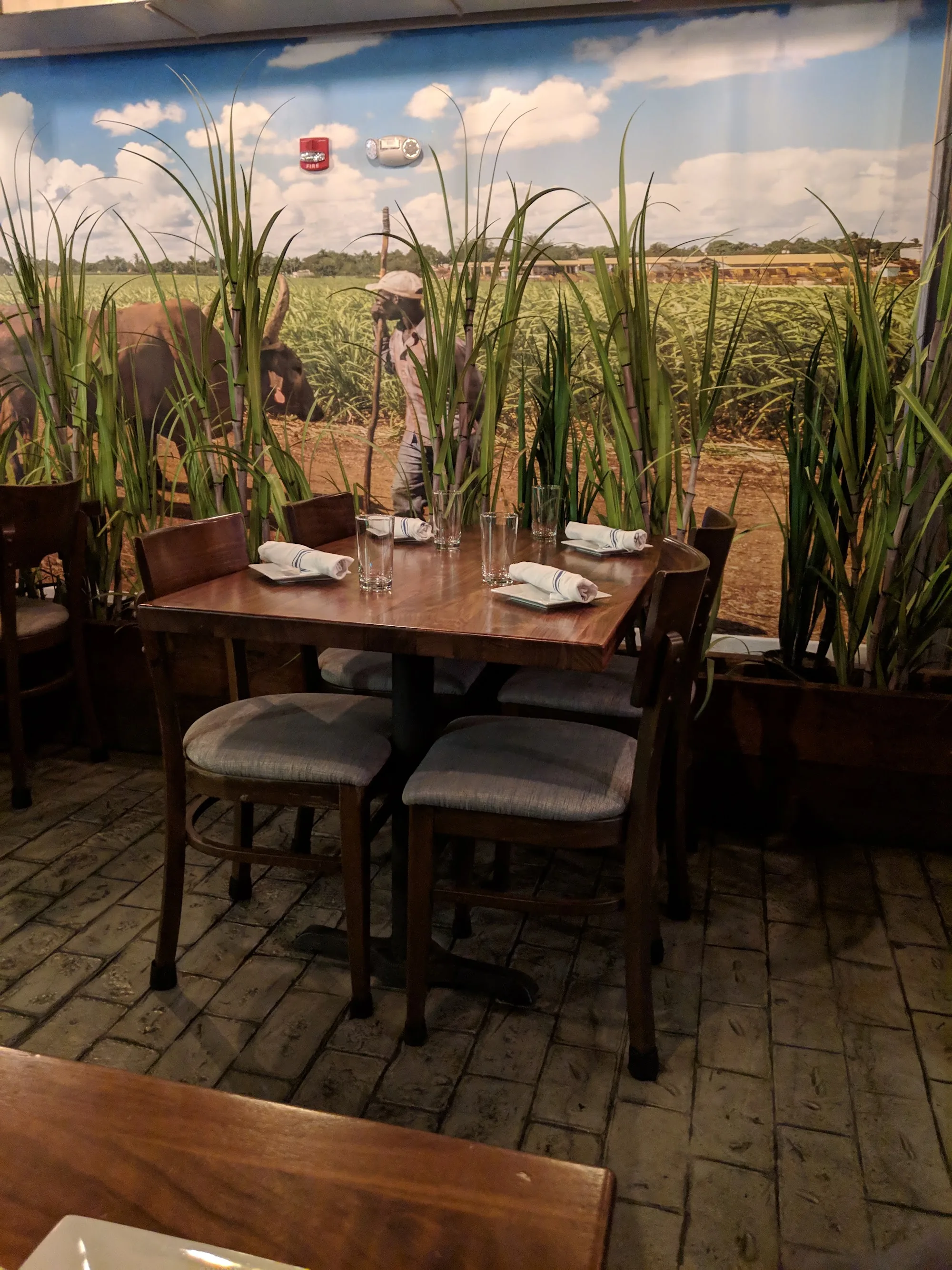 Table seating beside the Cuban sugarcane mural at La Fabrica Central