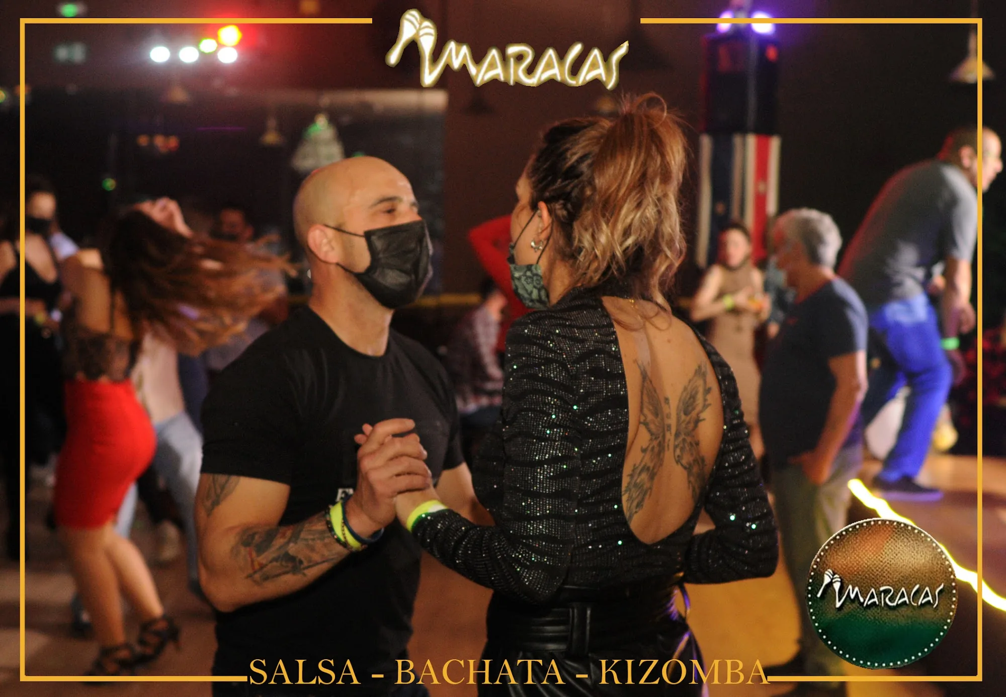 Salsa dancing couple on the Maracas dance floor with Maracas branding visible