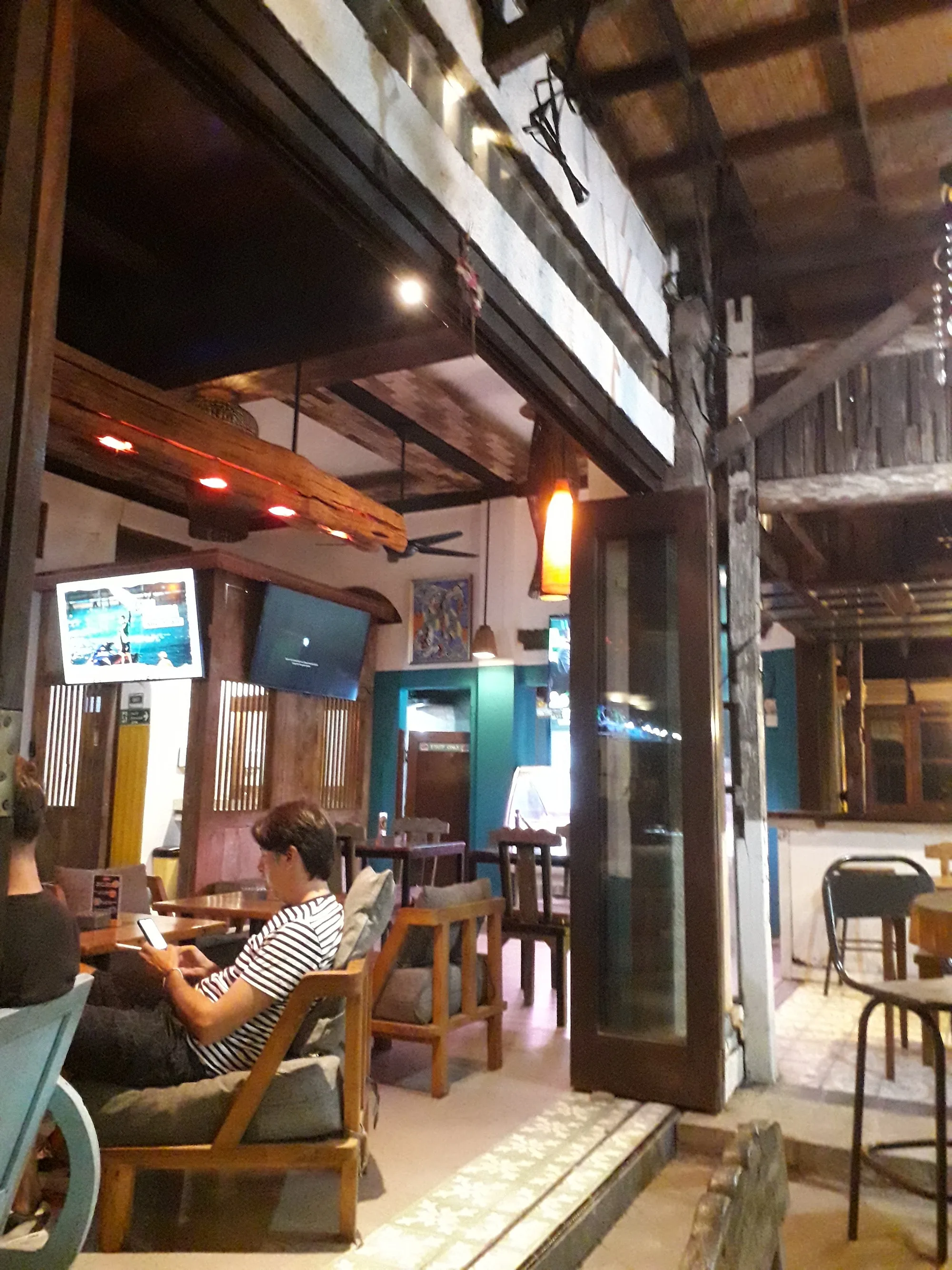 Warm wooden interior and lounge seating inside Litut Bar & Restaurant in Bali
