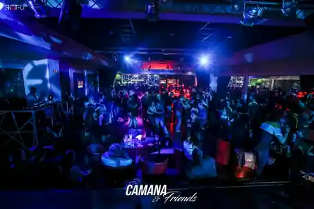 Crowded salsa dance floor with blue and red stage lighting at Camana Club Milan