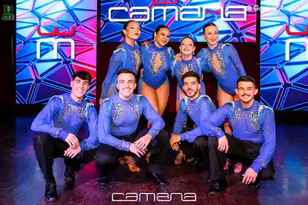 Latin dance team in blue costumes posing on the Camana Club stage in Milan — salsa, bachata, merengue, reggaeton, mix venue in Milan
