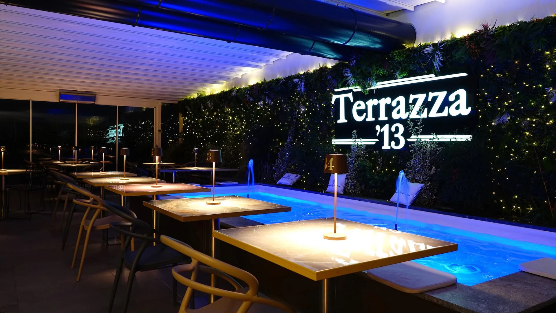 Outdoor terrace with branded Terrazza 13 signage and ambient blue lighting in Milan — bachata, salsa venue in Milan