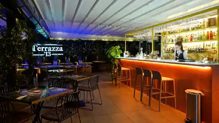 Illuminated bar with Terrazza 13 signage and lounge seating in Milan — bachata, salsa venue in Milan