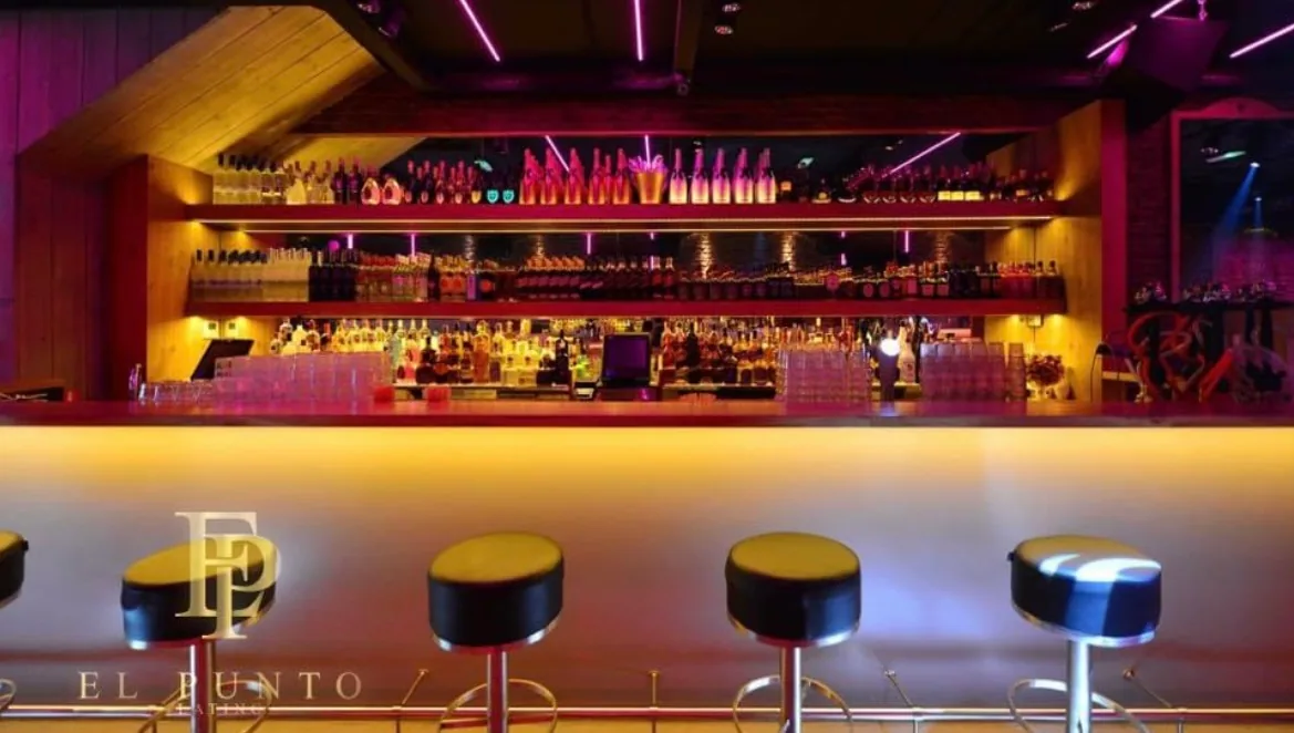 Bar interior at El Punto Latino Amsterdam with club lighting and bottle display
