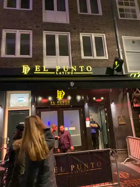 El Punto Latino Amsterdam venue entrance at night with branded sign and crowd outside — salsa, bachata, kizomba venue in Amsterdam